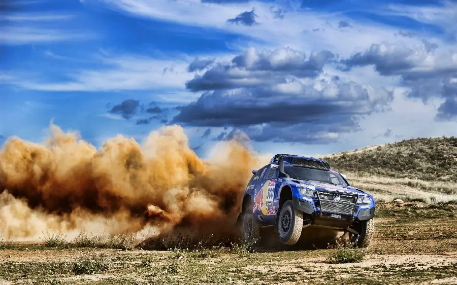 Photo of the dirt being kicked up in the Dakar Rally by a beautiful and magnificent Volkswagen car