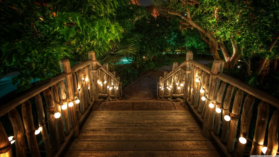 Beautiful dreamy night wallpaper of a wooden bridge and strings of chandeliers