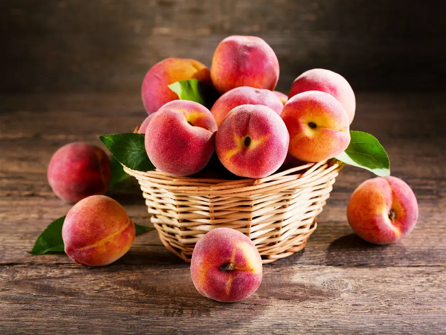 Photo of delicious and delicious peaches in a beautiful nostalgic wicker basket