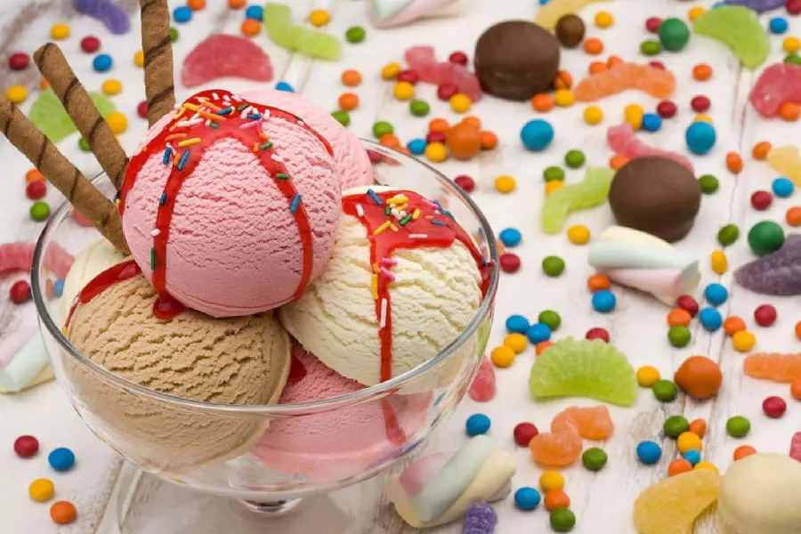 A view of delicious scoops of ice cream decorated with Smarties, pastels and marshmallows