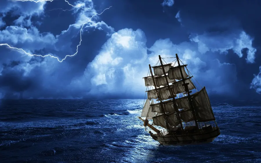 Picture of a sailing ship at sea under the lightning of the blue night sky