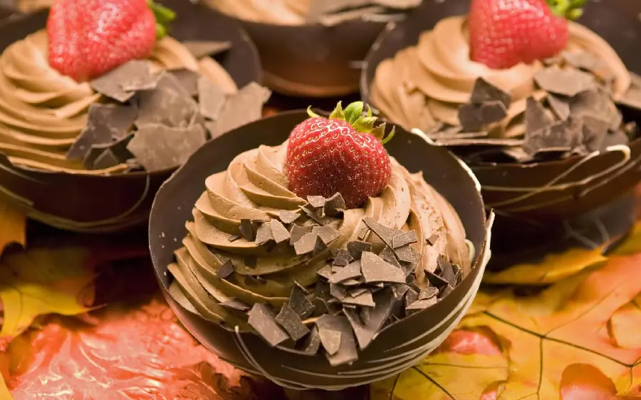 A very beautiful photo of ice cream with a desirable strawberry and chocolate decoration