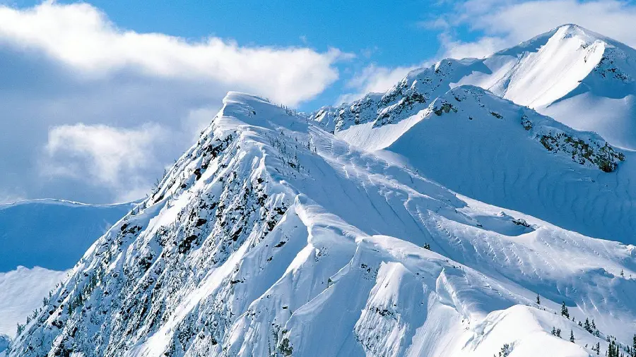 Stock photo Snow-covered mountains and pleasant white clouds 