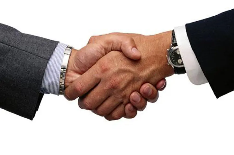Simple and real photo of two men shaking hands in suits 