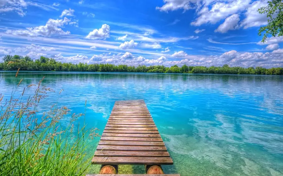 Spectacular profile of girls and boys with a beautiful wooden bridge design on a blue lake in summer