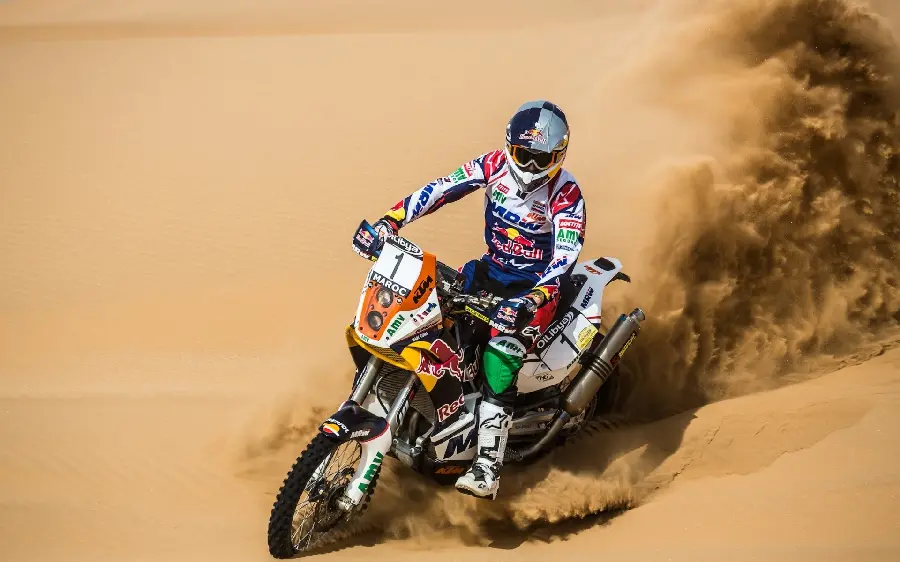 Fearless and brave motorcycle rider wallpaper in the Dakar Rally desert suitable for computer desktop