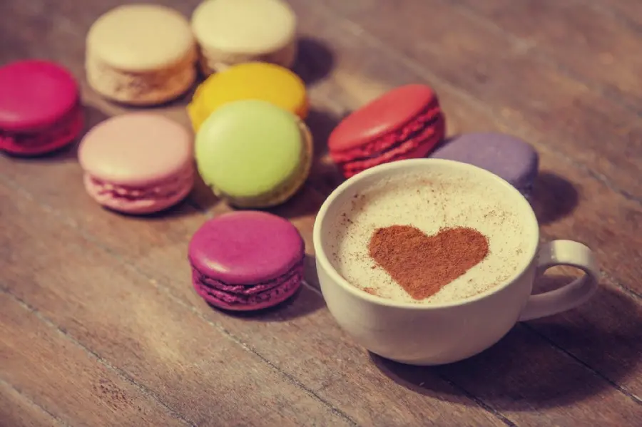 Beautiful wallpaper of heart-shaped coffee with delicious colorful macarons 