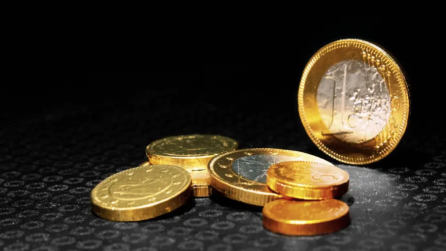 Wallpaper of several gold and silver coins with a dark background 