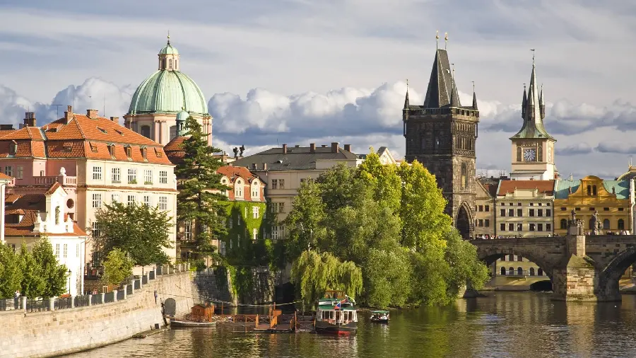 Image of a beautiful historical church with a green dome next to a pristine lake