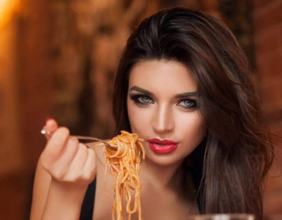 View of attractive girl serving pasta or spaghetti in restaurant