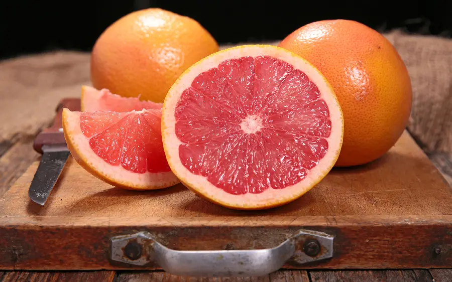 A charming and hearty poster of grapefruit served on a wooden board