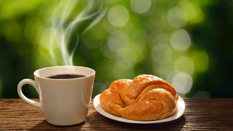 Lovely wallpaper of a cup of tea and croissants in nature