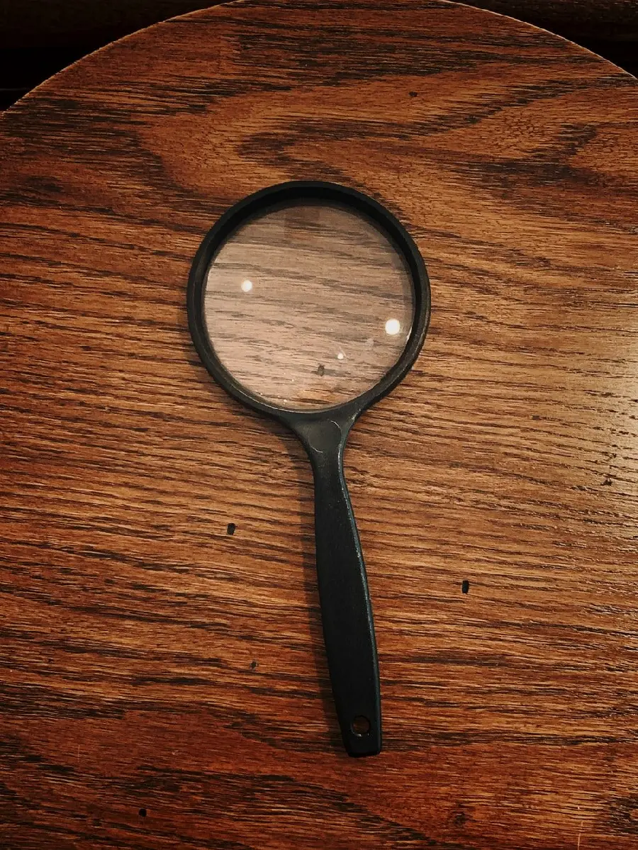  Beautiful and interesting photo of a magnifying glass on a wooden table in high quality 