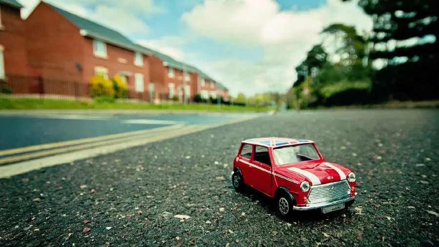 Stock photo of a red miniature car on the street suitable for printing 