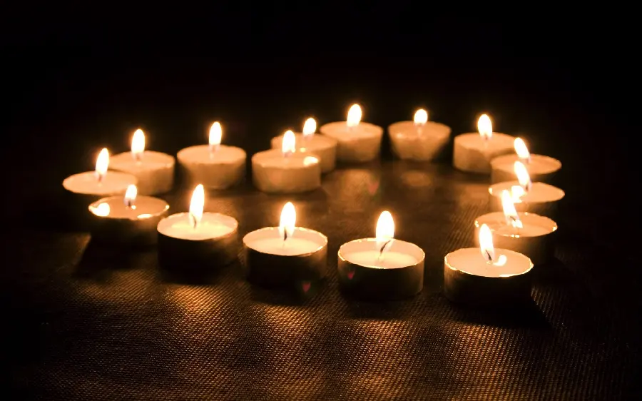 Image of candles arranged in the shape of a bright heart for condolences without text 