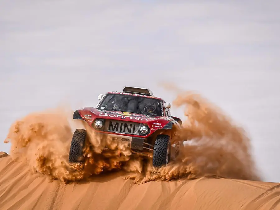 Image of the giant red car in the sand at the Dakar Rally in the country Saudi Arabia