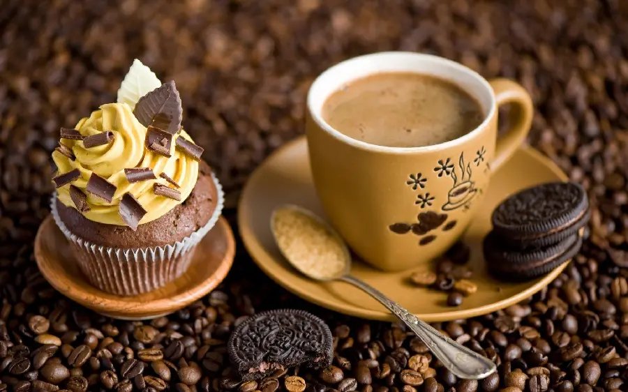 A charming picture of coffee with a delicious yellow cupcake in excellent quality 