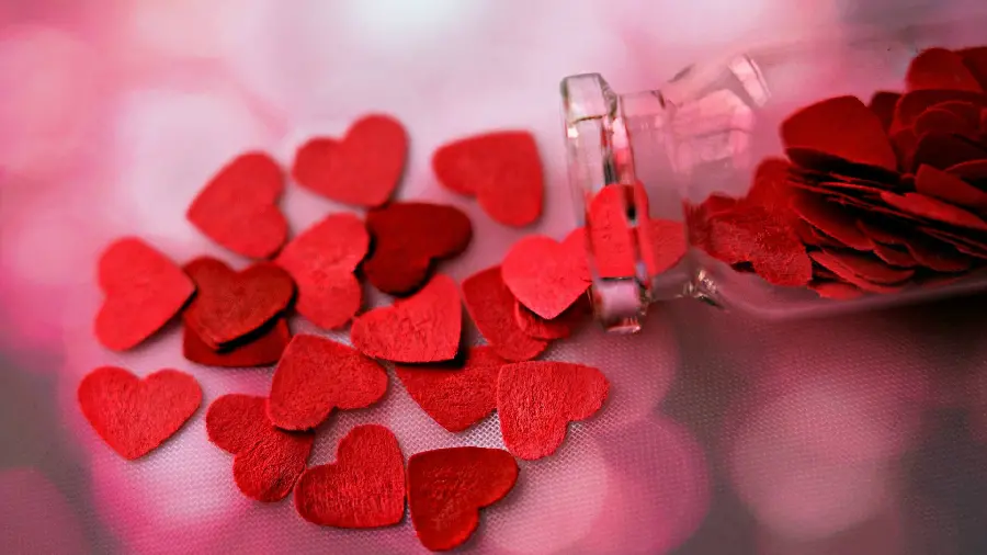 A unique photo of red paper hearts inside a glass 