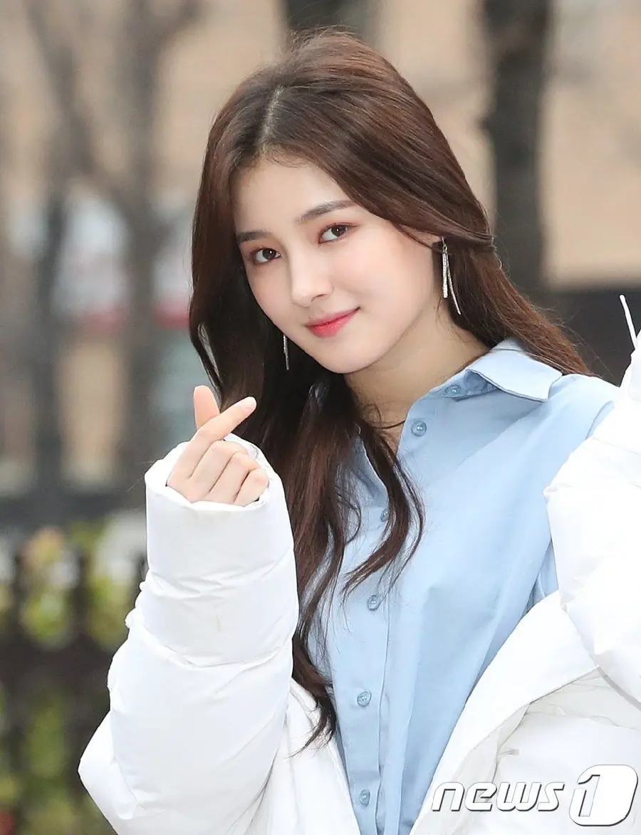 A Google photo of a popular Korean singer with a heart gesture and high quality
