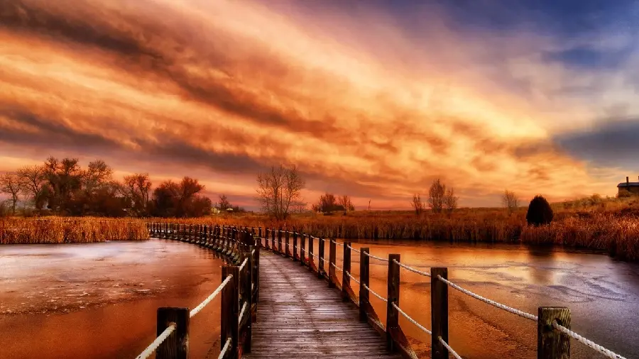 A picture of creating a work of art at sunset in front of an old bridge