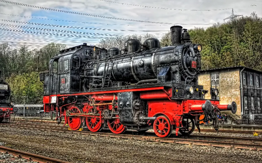 An interesting and spectacular view of an old locomotive in a beautiful red and black color