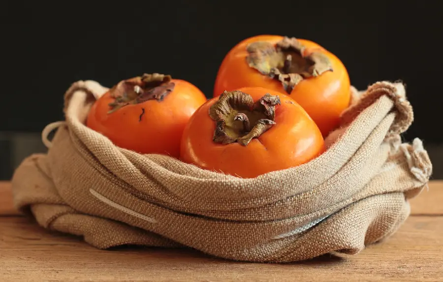 Background photo of a hemp sack and ripe persimmons arranged