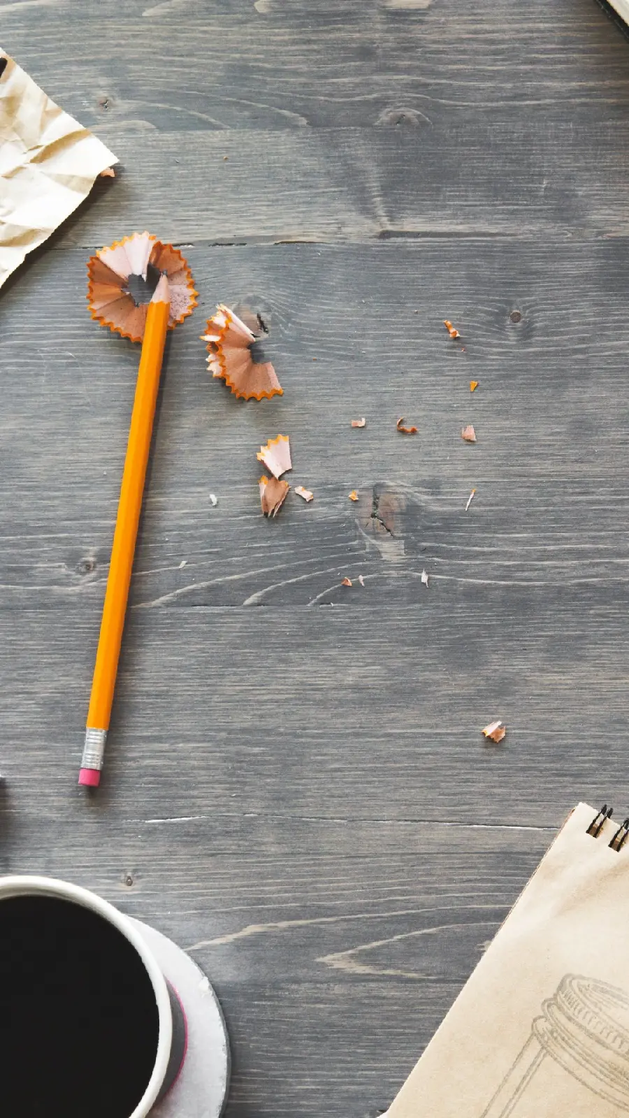 Interesting and visual image of a sharpened pencil next to a cup of coffee
