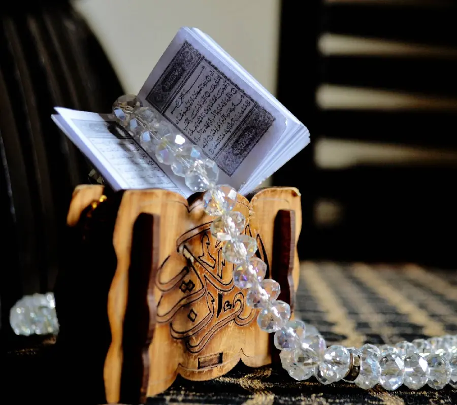 Amazing background A beautiful and interesting photo of a mini Holy Quran with beautiful rosary beads next to it 