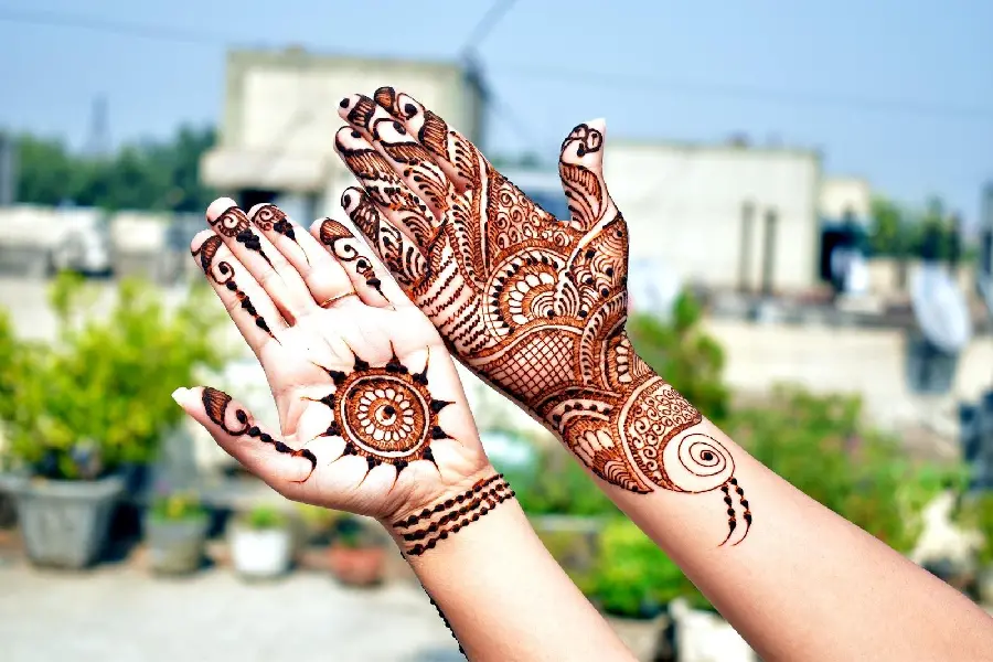 Beautiful model of henna on the palm with a combined wicker and curved pattern