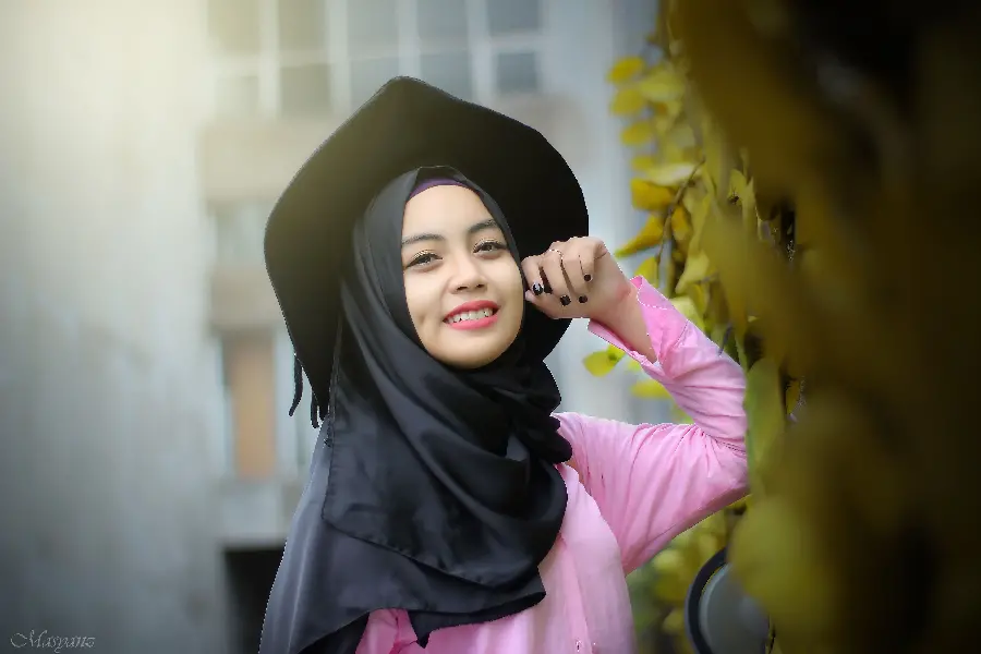 Background of a beautiful and smiling girl in a hijab with dimples and a hat
