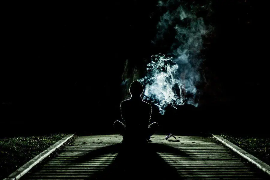 Sad and sad smoking boy profile picture with a black background 