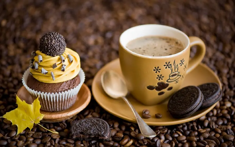Photo of creamy yellow cupcake with autumn leaves next to it 