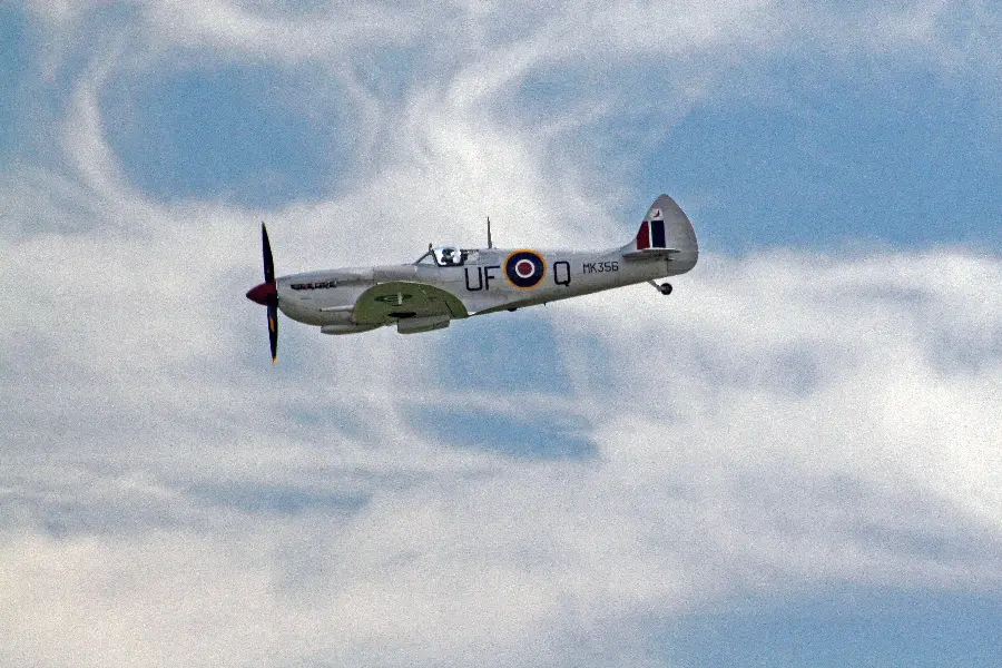 A picture of an old silver airplane in the sky with excellent quality
