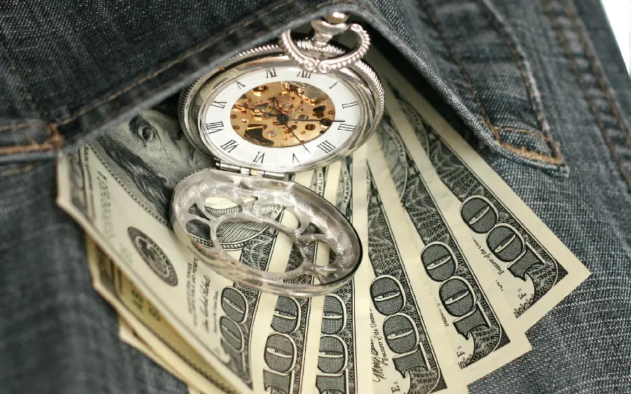 Get an attractive background of a golden watch on a hundred dollar bill