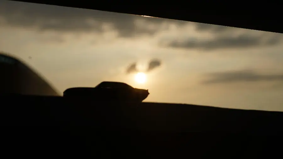 Photo of the shadow of a small miniature car at sunset