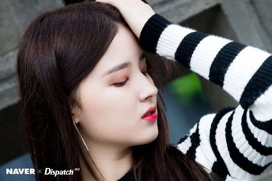 A profile view of Nancy in a black dress with striped sleeves