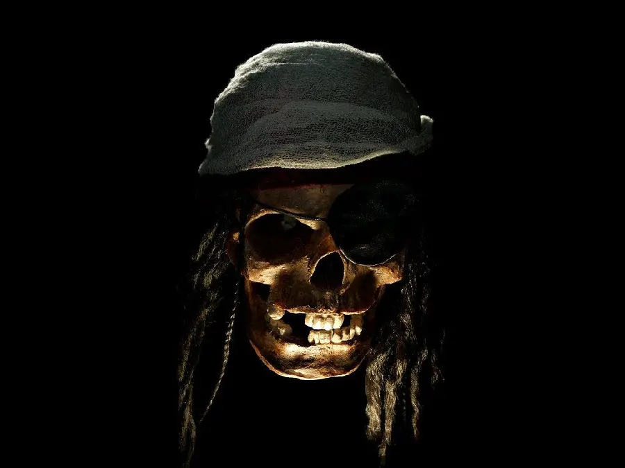 Scary image of yellow pirate skull with hair and white headband