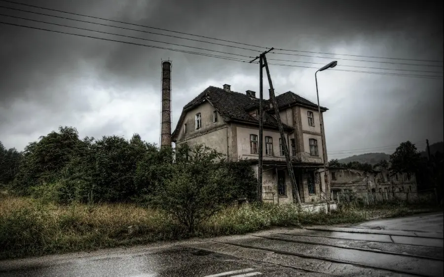 A scary picture of an abandoned and old house on a rainy street