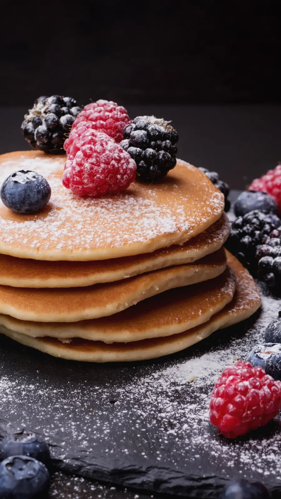 The clearest close-up photo of pancakes decorated with blackberries