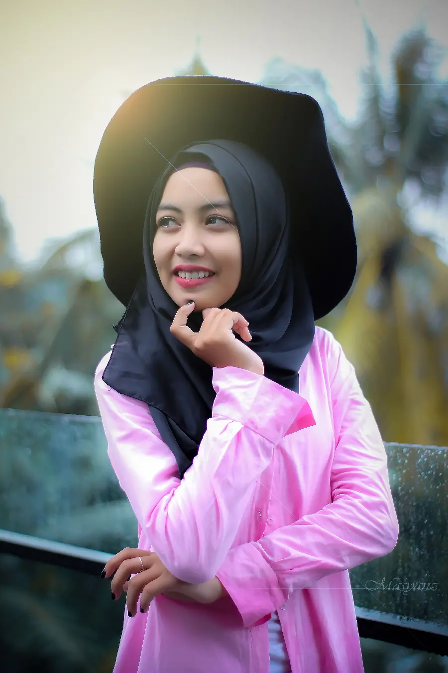 Wallpaper of an artist girl with a hijab in a black hat and a beautiful pink dress