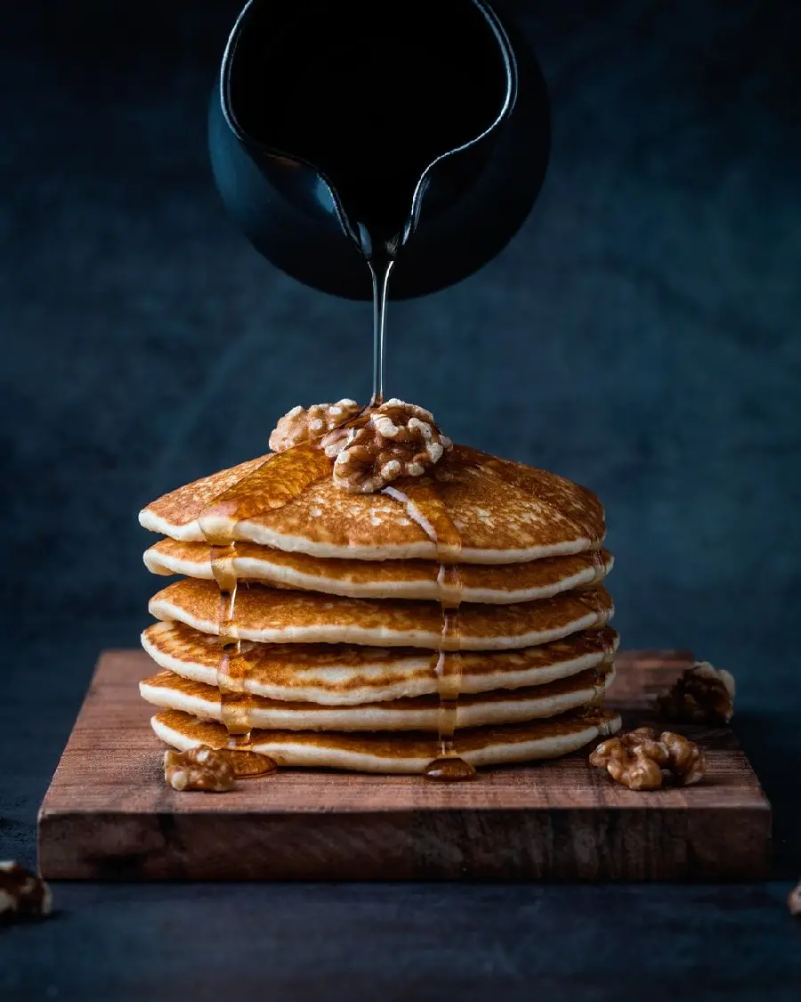 Image of a delicious pancake decorated with walnuts with a black background