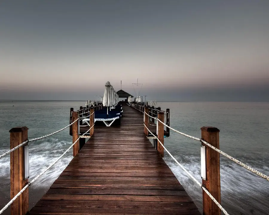 Get a stock photo of a stormy sea and waves crashing against the bridge
