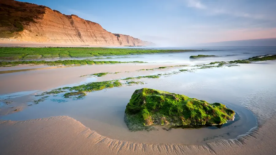 Indescribable background of the sea and the smooth beach next to the mountain