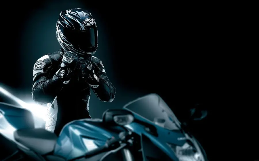 4K image of a boy in black with a helmet and motorcycle clothing