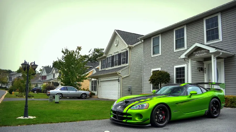 Stylish and spectacular wallpaper of adjacent buildings and a green sports car
