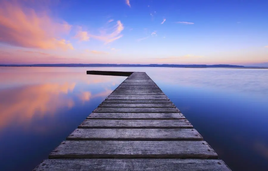 Amazing and imaginative wallpaper of a sunset on the sea and a wooden bridge