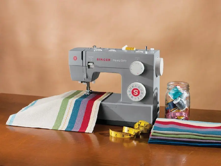 Beautiful image of a modern gray Singer sewing machine on a wooden table