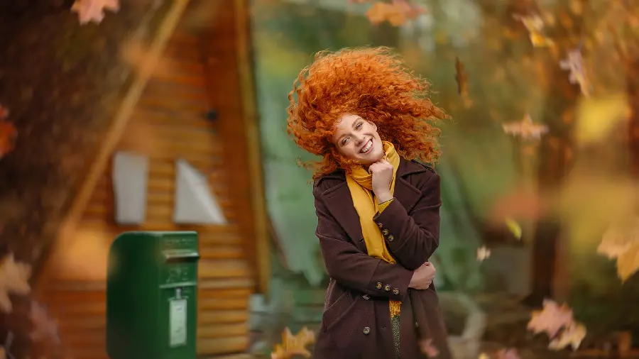 Stylish and special profile photo of a curly orange girl in a dreamy autumn forest in HD quality