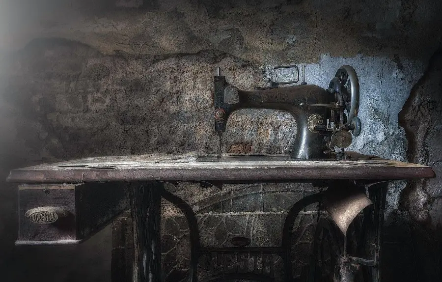 Photo of an old VESTA sewing machine on an old handmade table 