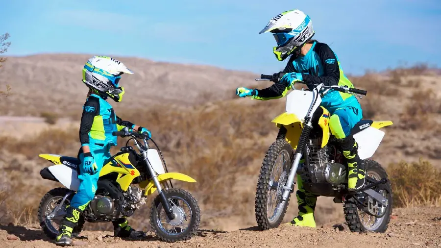Wallpaper of a child learning to ride a motorcycle with a trail motorcycle